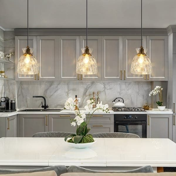 A Kitchen With Marble Counter Tops And Gold Accents On The Cabinets ... pertaining to The Designer's Touch Selecting Modern Pendant Lights for a Cohesive Island Look